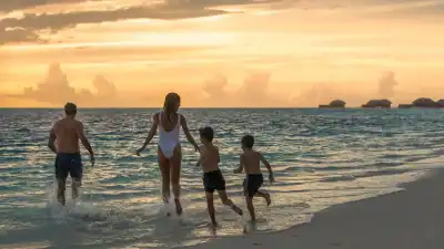 Family on the beach at sunset